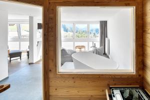 una sala de estar con una gran ventana en una casa en Hotel Kühberg, en Oberstdorf