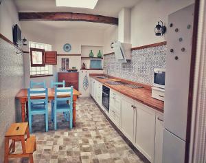 une cuisine avec une table en bois et des chaises bleues dans l'établissement Casa en La Ladera - Real vibe - Beach & Mountain, à San Nicolás