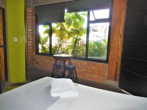 a bed in a room with a window and a stool at Hospedaje Neydita in Iquitos
