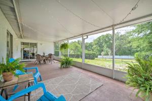 un porche vacío con sillas azules, mesas y ventanas en Apopka Family Home Near Downtown 30 Mi to Disney! en Orlando