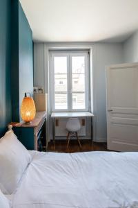 um quarto com uma cama, uma secretária e uma janela em L'Indigo- Coup de coeur Canut - Croix Rousse em Lyon