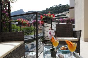 a balcony with a table with two glasses of orange juice at Aretusa Resort Amalfi Coast in Vietri sul Mare