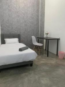 a bedroom with a bed and a table and a chair at Mini Rest Room (Mini but 99% Full Equipped) in Bukit Mertajam