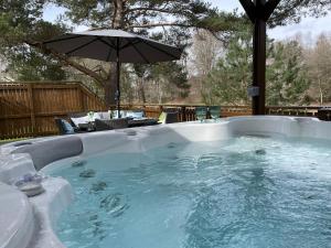 een hot tub met parasol in de achtertuin bij Luxury Riverside Lodge, Blair Atholl in Pitlochry