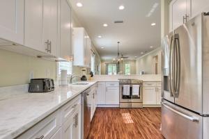 a large kitchen with white cabinets and stainless steel appliances at Lovely Mobile Retreat with Deck and Front Porch! in Mobile