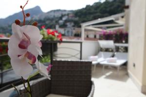 a white flower in a vase on a balcony at Aretusa Resort Amalfi Coast in Vietri sul Mare