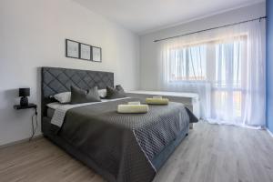 a bedroom with a large bed with two yellow towels on it at Apartman Dora in Crikvenica