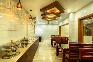 ein Restaurant mit Theke, Stühlen und Tischen in der Unterkunft Daan Regency in Thrissur