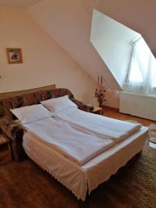 - une chambre mansardée avec un grand lit dans l'établissement Fodor Vendégház, à Racu