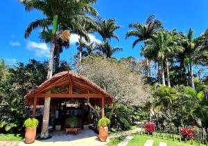 a pavilion in a garden with palm trees at Taman Búzios Hotel in Búzios