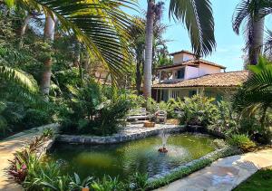 ブジオスにあるTaman Búzios Hotelの家の前に池のある庭