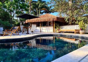 ブジオスにあるTaman Búzios Hotelのスイミングプール(テーブルと椅子付きの小屋付)