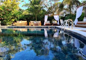 ブジオスにあるTaman Búzios Hotelのラウンジチェア付きのスイミングプールが隣接しています。