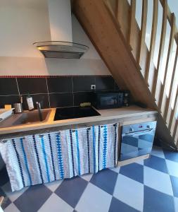 - une cuisine avec un comptoir, une cuisinière et un évier dans l'établissement Le Stud' à Saint Pierre d'Oléron !, à Saint-Pierre-dʼOléron