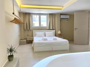 1 Schlafzimmer mit einem weißen Bett und einer Badewanne in der Unterkunft Pool Villa Lagonisi 5min from Beach in Koropi