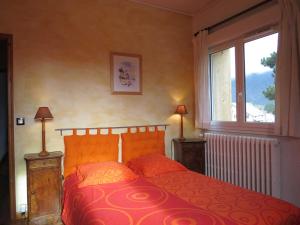 1 dormitorio con cama roja y ventana en Gîte SOLDANELLE - 15 personnes - "Les Gites du Chalet" à Autrans en Autrans