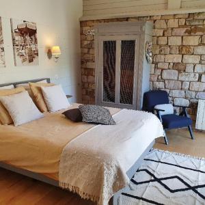 a bedroom with a bed and a brick wall at B&B Maison Pierreuse in Sart-lez-Spa
