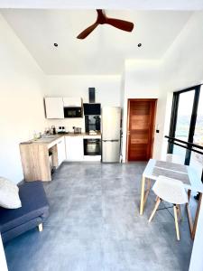 uma sala de estar com uma ventoinha de tecto e uma cozinha em L'Été sans fin, vue montagne em Filaos