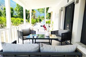 a patio with a couch and a table on a porch at Villa Narlibahce in Ortaca