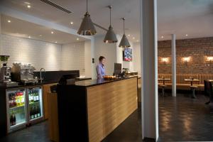 a man standing at a bar in a restaurant at The Z Hotel Glasgow in Glasgow