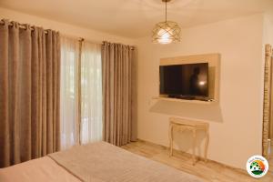 sypialnia z łóżkiem i telewizorem na ścianie w obiekcie Hotel Finca Naranjal w mieście Granada