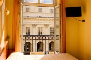 a room with a window with a view of a building at Hotel de L'Opéra in Bordeaux