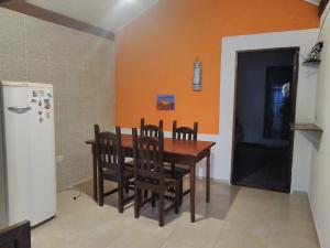 een eetkamer met een tafel en stoelen en een koelkast bij Siqueira, aluguéis para temporadas in Paraty