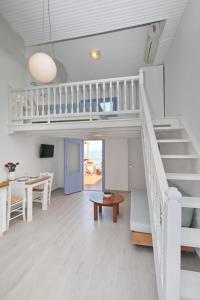 a living room with a staircase and a table at Skopelos Aerino house in Skopelos Town