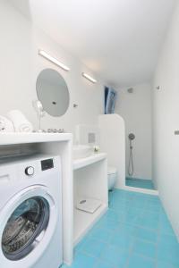 een badkamer met een wasmachine en een wastafel bij Skopelos Aerino house in Skopelos Town