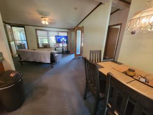 a living room with a bed and a table at Camp Not Found - 3 Queen Bedrooms by the lake in Hartstown