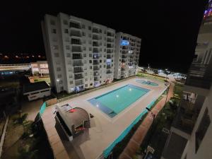 una piscina frente a un edificio por la noche en Apartamento Aqualina Orange Piso Octavo Vista a Piscina, en Girardot