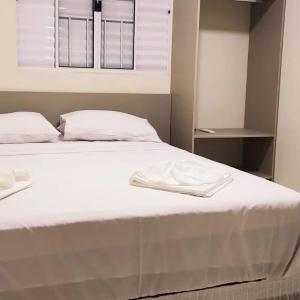 a bed with two white towels on top of it at EL SHADDAY HOTEL in Diamante do Norte