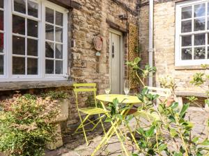 een gele tafel en stoelen voor een gebouw bij 3 George Yard in Burford