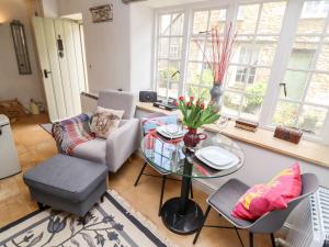a living room with a glass table and chairs at 3 George Yard in Burford