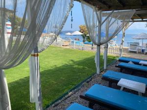 een groep blauwe stoelen onder een tent met het strand bij Cundavilla Hotel & Suites in Ayvalık