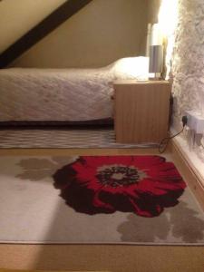 a bedroom with a red flower on the floor at The Annexe at Pridden in Saint Buryan