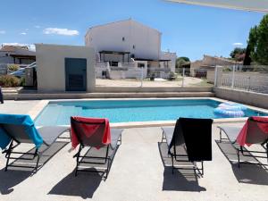 a group of chairs sitting next to a swimming pool at LES MAISONS DU PATY in Arles +20 photos