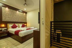 a bedroom with a bed with red pillows at Daan Regency in Trichūr