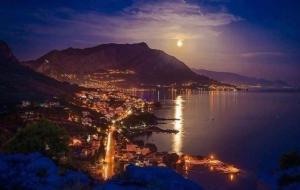 - une vue sur une ville la nuit avec la lune dans l'établissement Apartments Diridonda, à Omiš