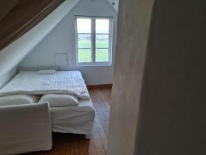 a small bedroom with a bed and a window at Villa Vemmentorp - Körsbärsblomsvillan 6 min från havet in Skurup