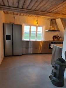 a large kitchen with stainless steel appliances and a window at Villa Vemmentorp - Körsbärsblomsvillan 6 min från havet in Skurup