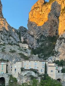 a city in front of a mountain at Hôtel Particulier des Lumières in Moustiers-Sainte-Marie