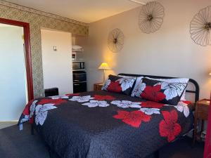 een slaapkamer met een bed met een zwarte en rode deken bij Sugarloaf Mountain Motel in Virginia City