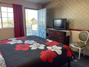 um quarto com uma cama e uma televisão numa cómoda em Sugarloaf Mountain Motel em Virginia City