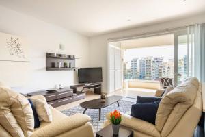 a living room with two couches and a tv at Luxury Seafront 2 bedroom apartment in Spinola Bay in St. Julianʼs