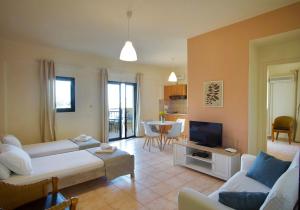 a living room with a couch and a tv at Lygaria Beach Apts in Ligaria