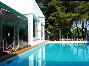 a swimming pool next to a house at Hotel Kyrie Isole Tremiti in San Domino