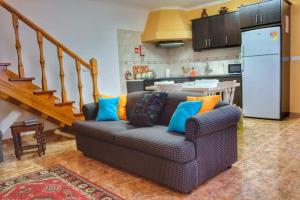 a living room with a couch and a kitchen at Ribeirinha House in Porto Formoso