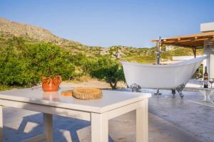 Panstel Bungalows in Kerames Rethymno في Kerames: طاولة وحوض الاستحمام على الفناء