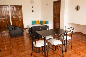 Zimmer mit einem Tisch, Stühlen und einem Sofa in der Unterkunft RinaKawsay - ViveViajando HERMOSO Penthouse completamente amoblado en TENA in Tena